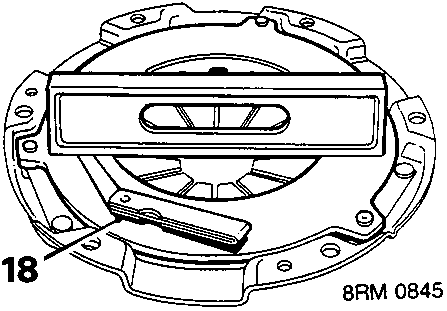 Pressure plate shown with a straight edge and feeler gauge checking surface flatness at callout point 18